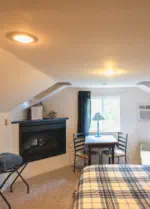 tv and gas fireplace and small seating area in suite