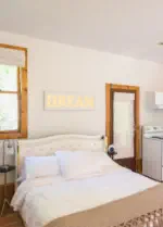 queen bed with stove, fridge and breakfast nook in vacation rental