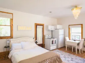 queen bed with stove, fridge and breakfast nook in vacation rental