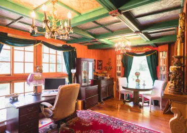 cozy study room with wood paneling and decorative ceiling