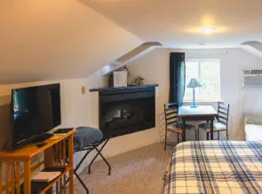 tv and gas fireplace and small seating area in suite